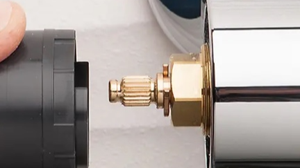 Close-up of a plumbing valve being attached to a pipe.